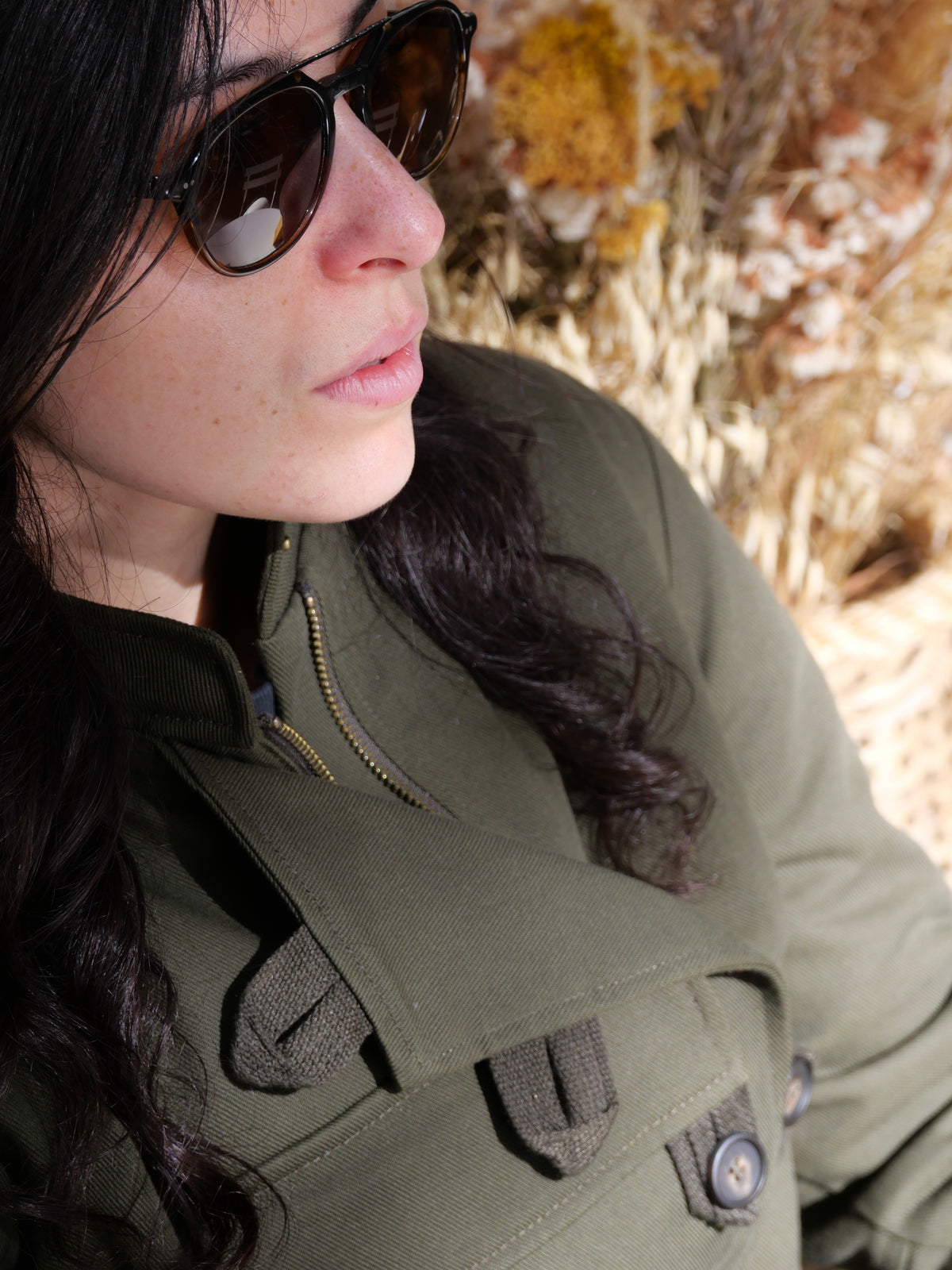 Détail de la veste DONNA Armalith kaki portée, avec le col et la poche poitrine visibles.