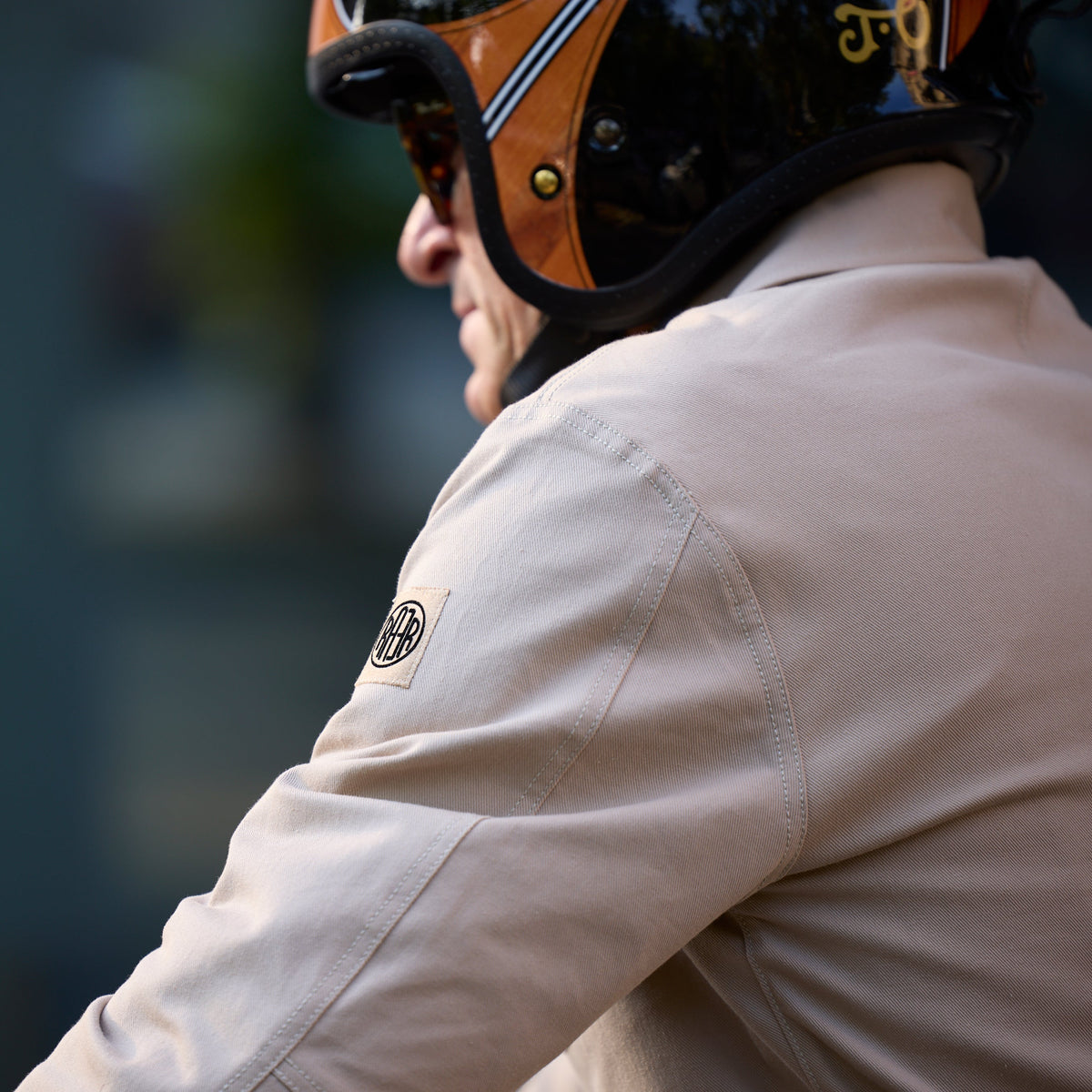Épaule et logo de manche de la veste ARTIST beige portée avec un casque.