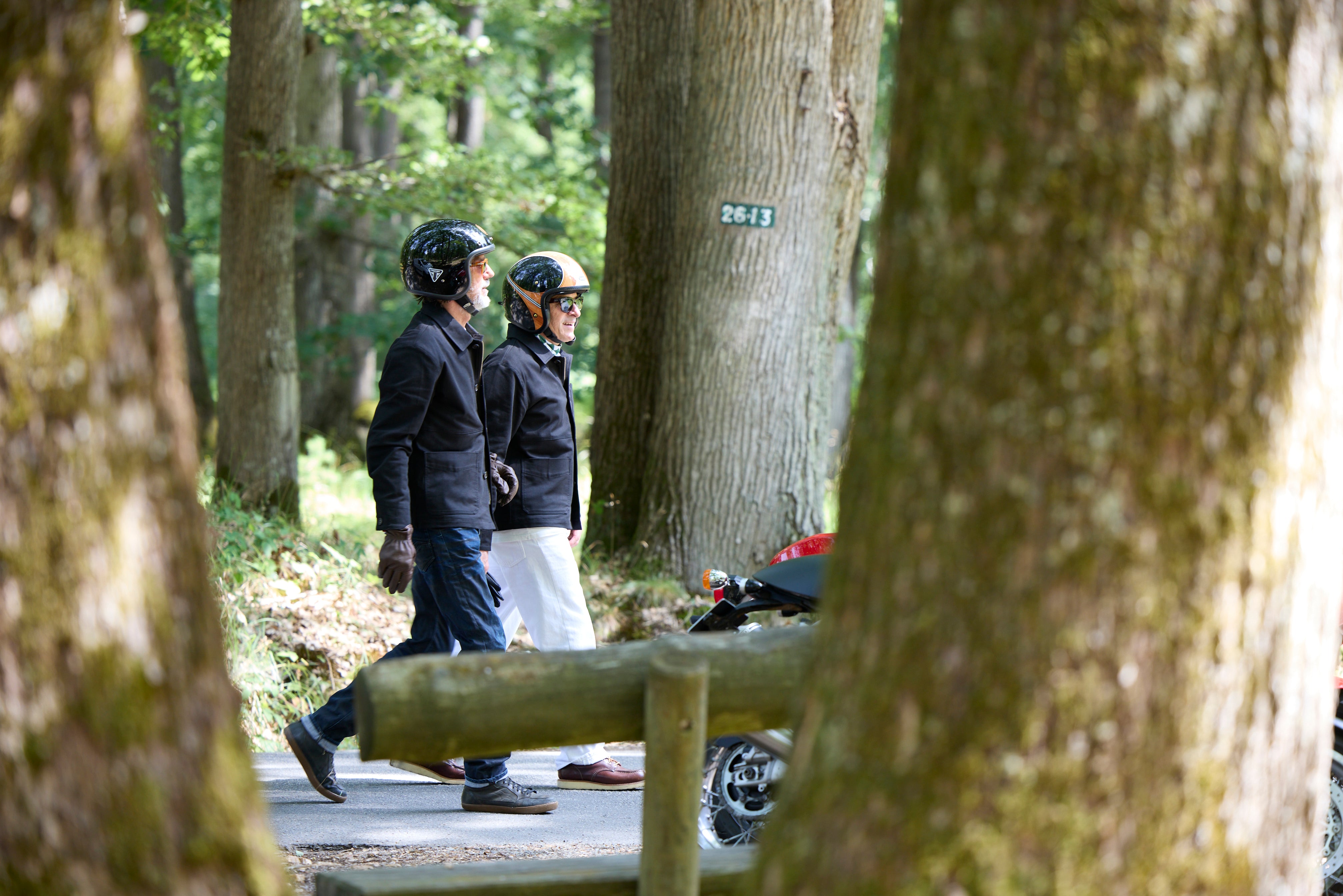 Deux hommes en veste RAER et casque marchant dans une forêt