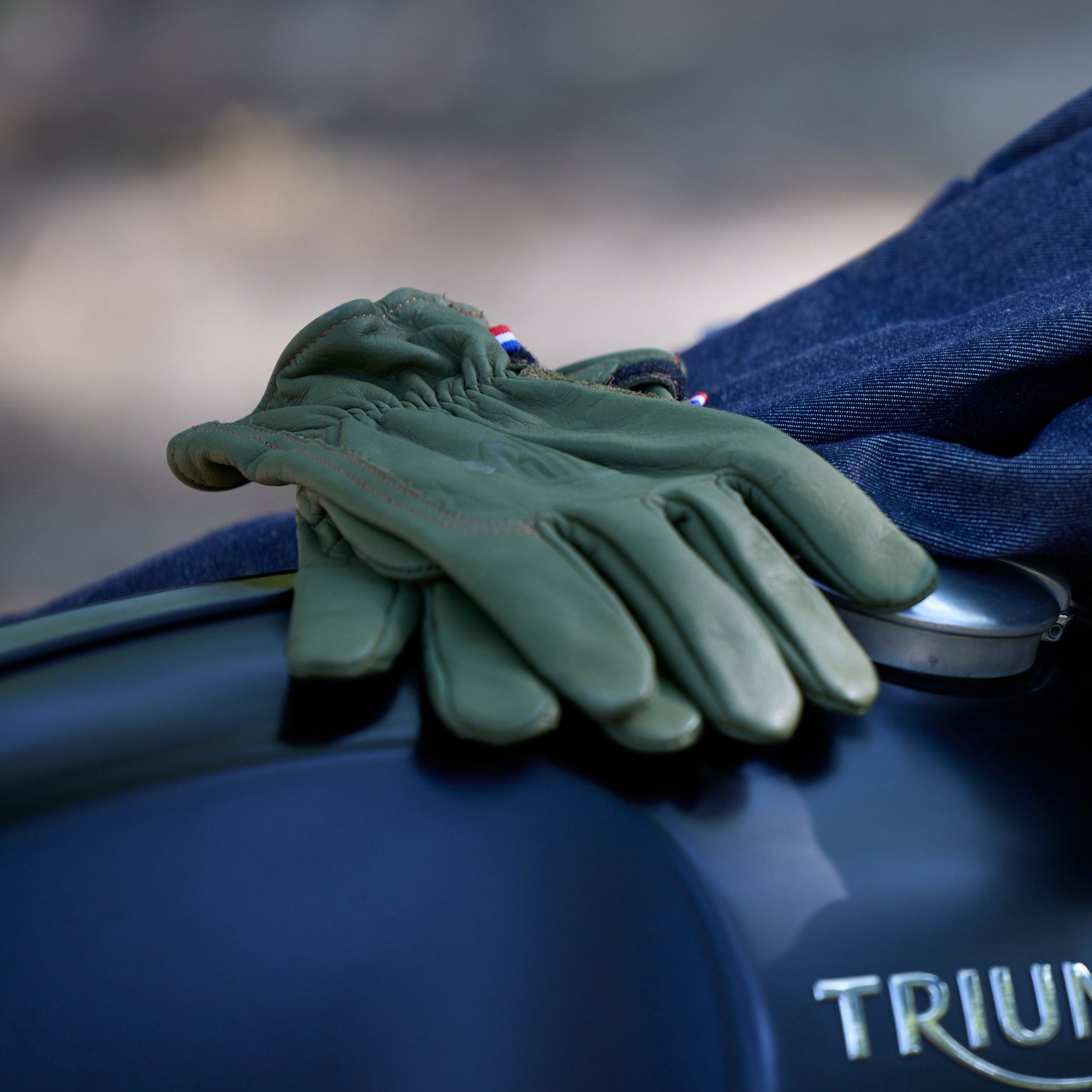 Gants en cuir vert posés sur une moto
