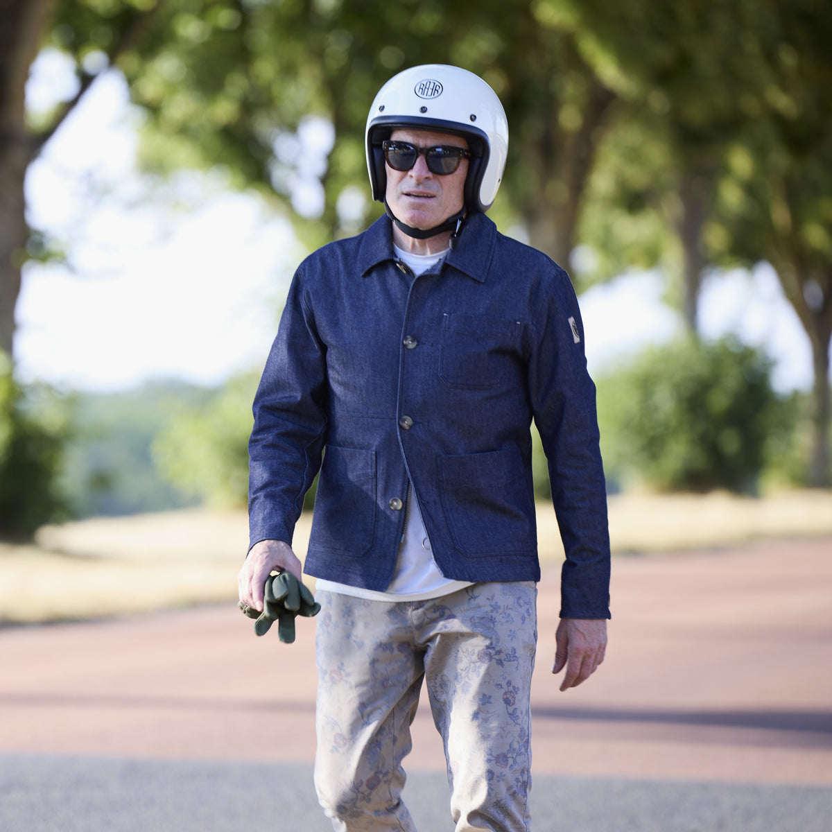 Veste ARTIST Denim portée debout avec un casque blanc, des gants à la main.