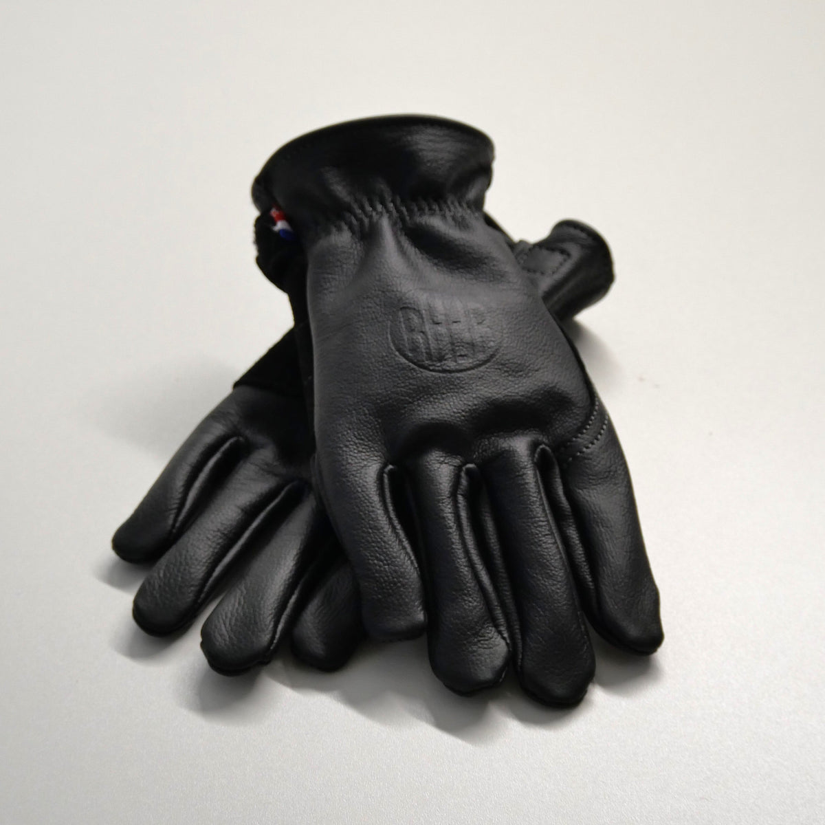 Paire de gants APPLE 3 noirs en cuir, posés l’un sur l’autre.