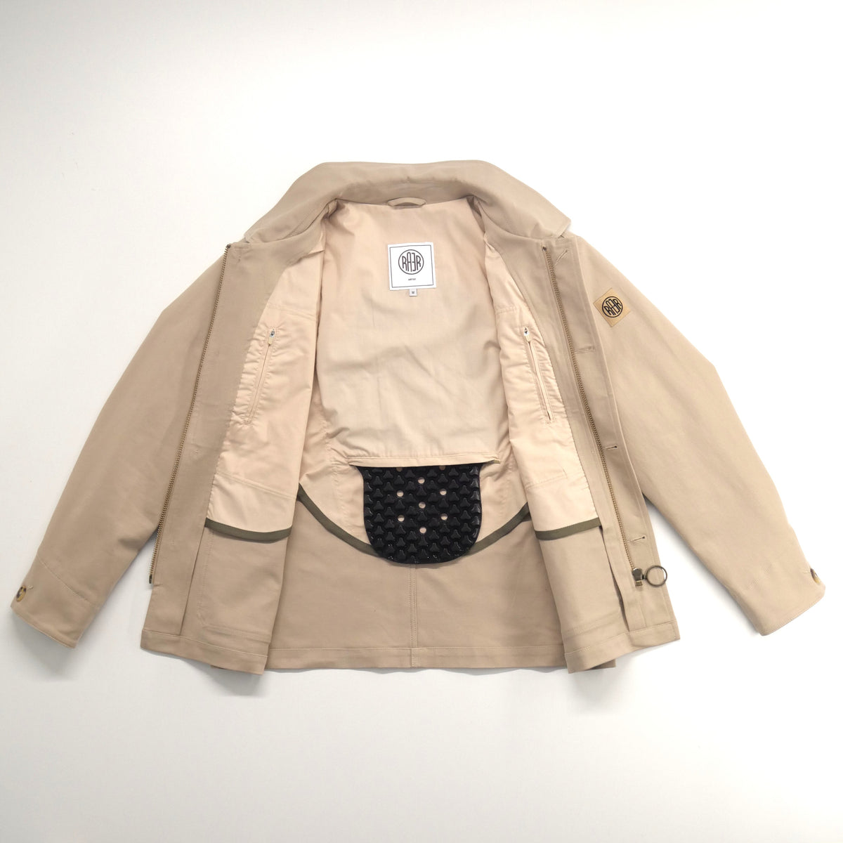Veste ARTIST beige ouverte, avec la protection dorsale visible dans la demi-doublure claire.