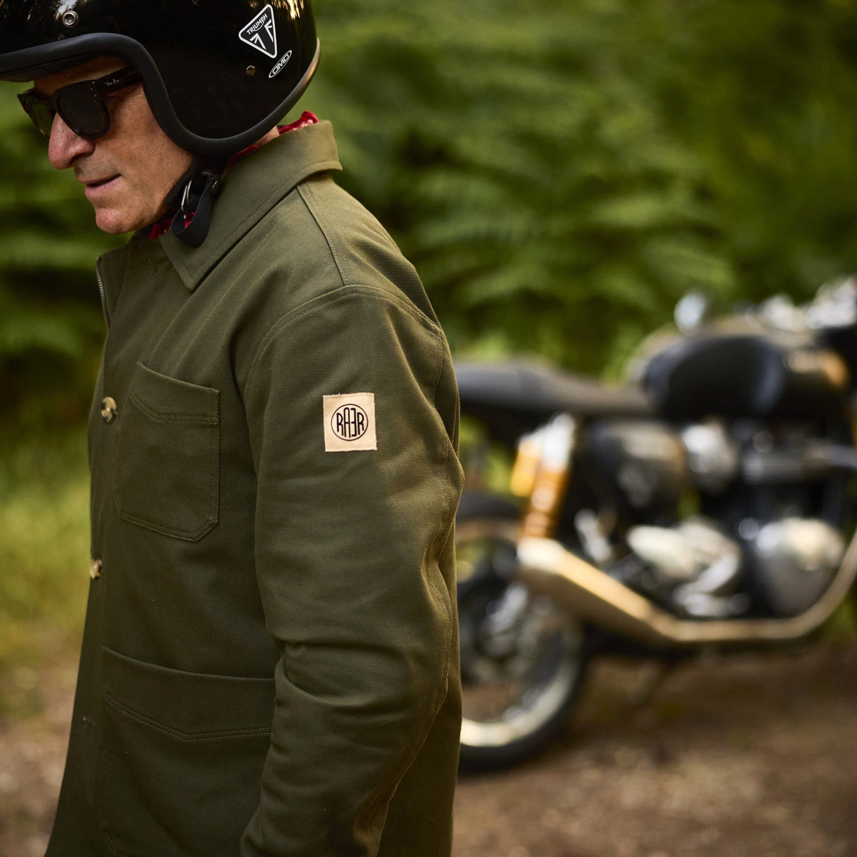Veste ARTIST kaki portée de profil, avec le logo RAER sur la manche.