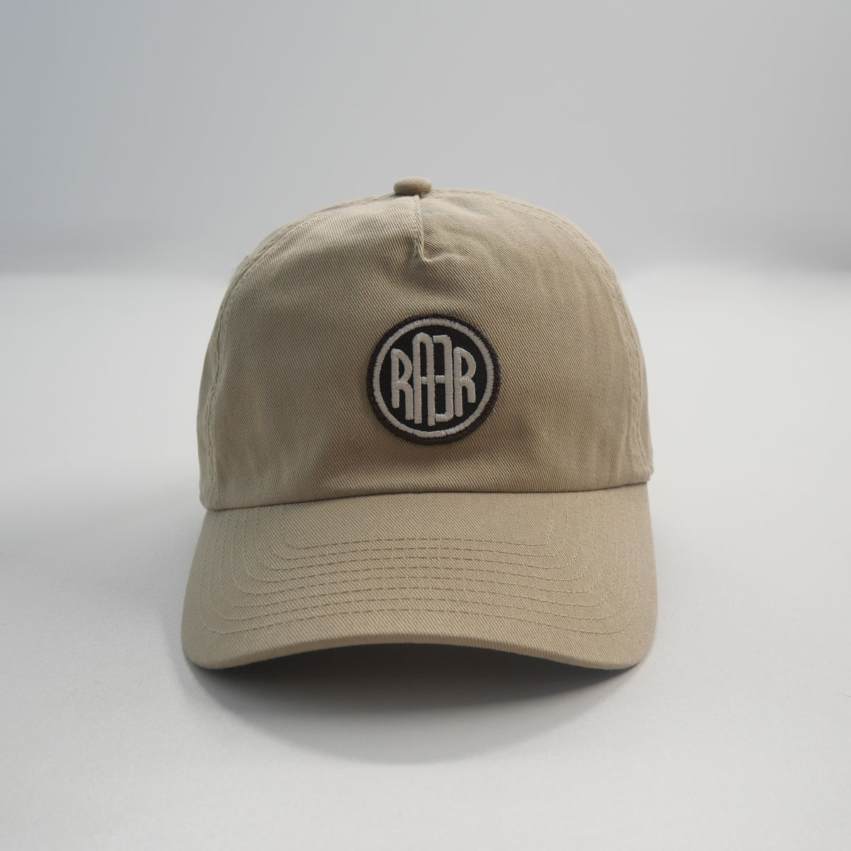 Casquette ORIGINAL beige vue de face, avec badge RAER centré au-dessus de la visière.