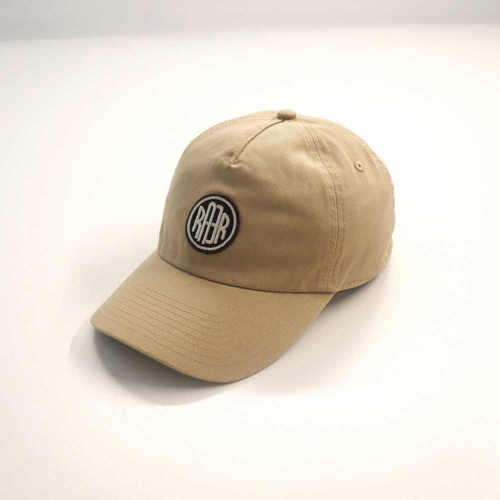 Casquette ORIGINAL beige vue de trois quarts, avec badge RAER et visière courbe.