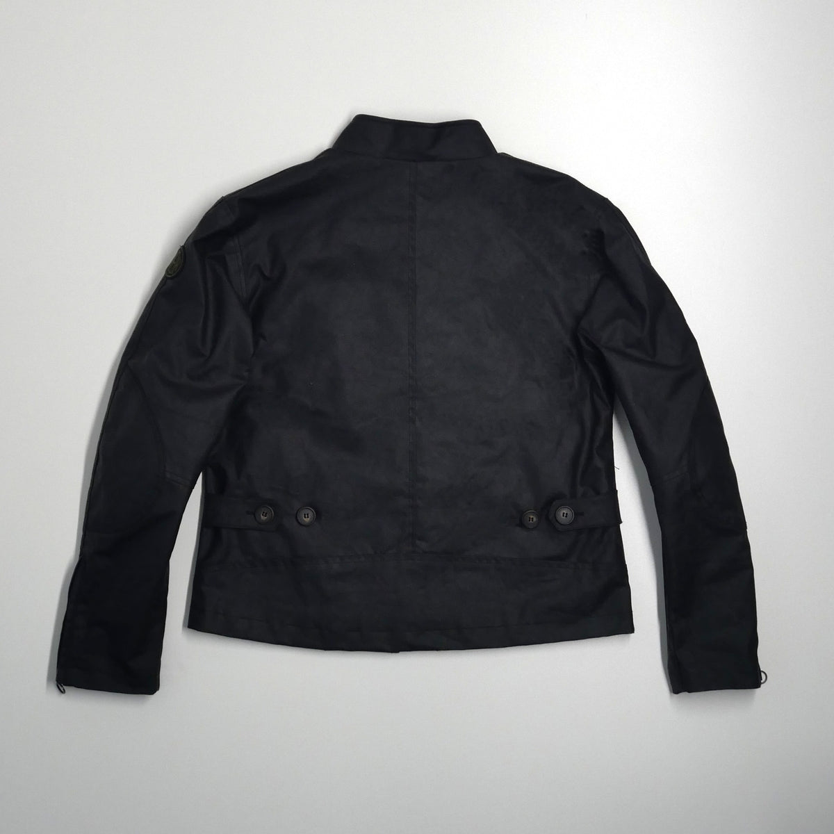 Veste DONNA Wax noire posée à plat, vue de dos avec les réglages à la taille.