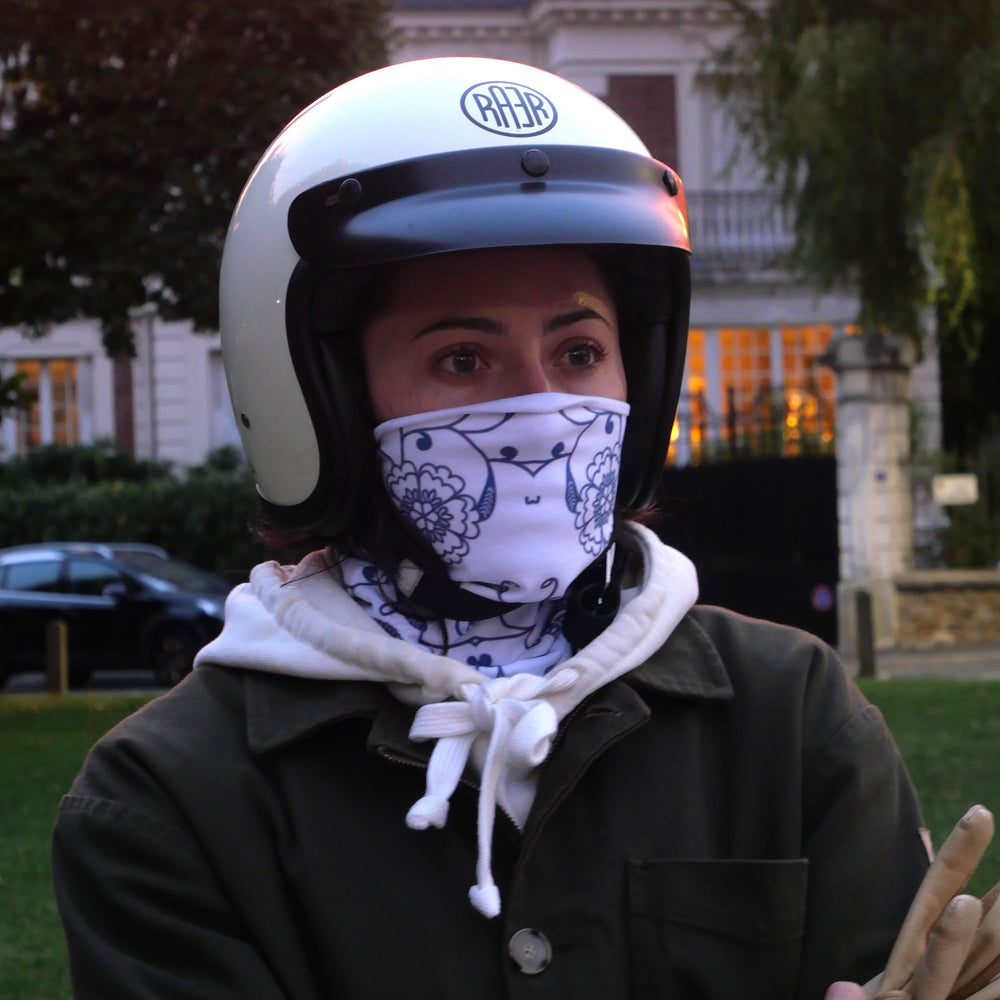 Tour de cou JOY à motifs bleus porté sur le nez avec un casque blanc.