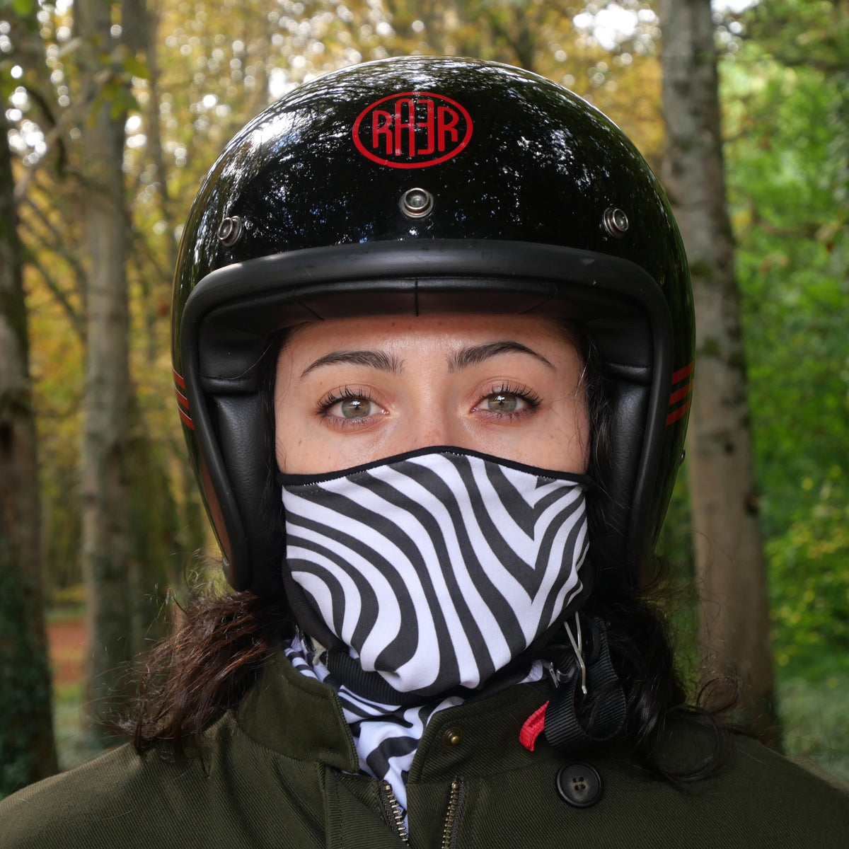 Tour de cou ZEBRA à rayures noires et blanches porté sur le nez avec un casque noir.