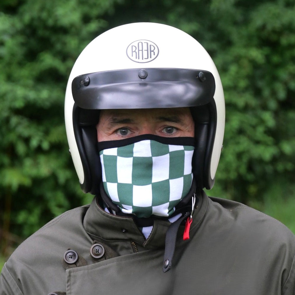 Tour de cou FLAG vert et blanc porté sur le nez avec un casque blanc.