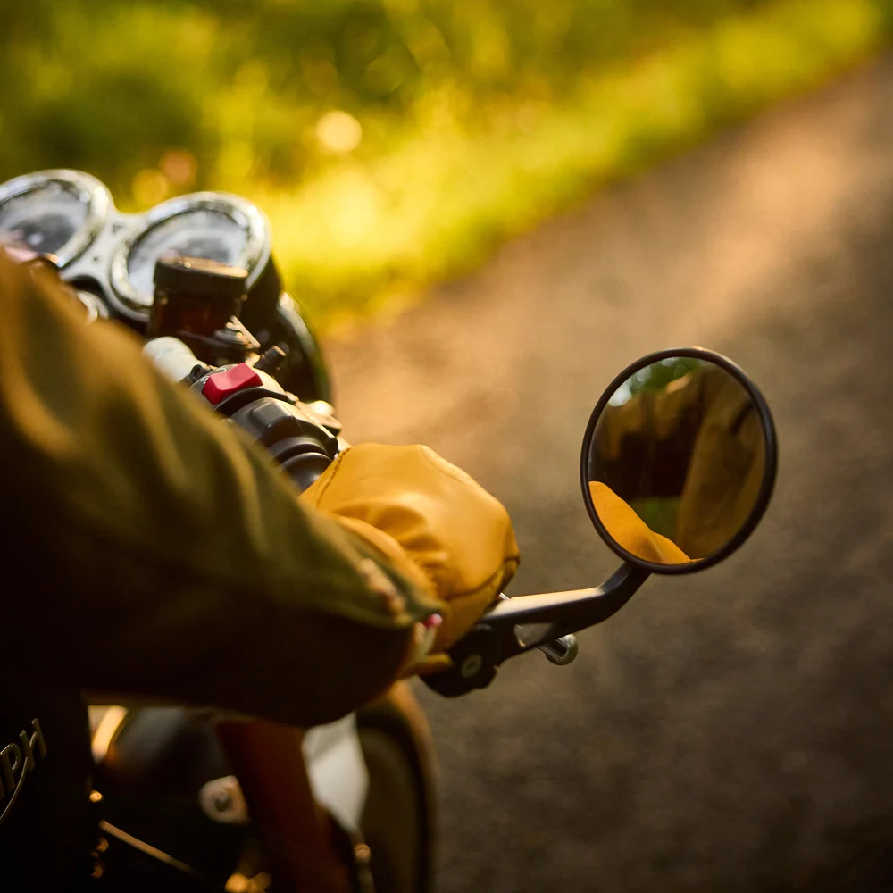 Détail d'un gant de moto sur une route ensoleillée